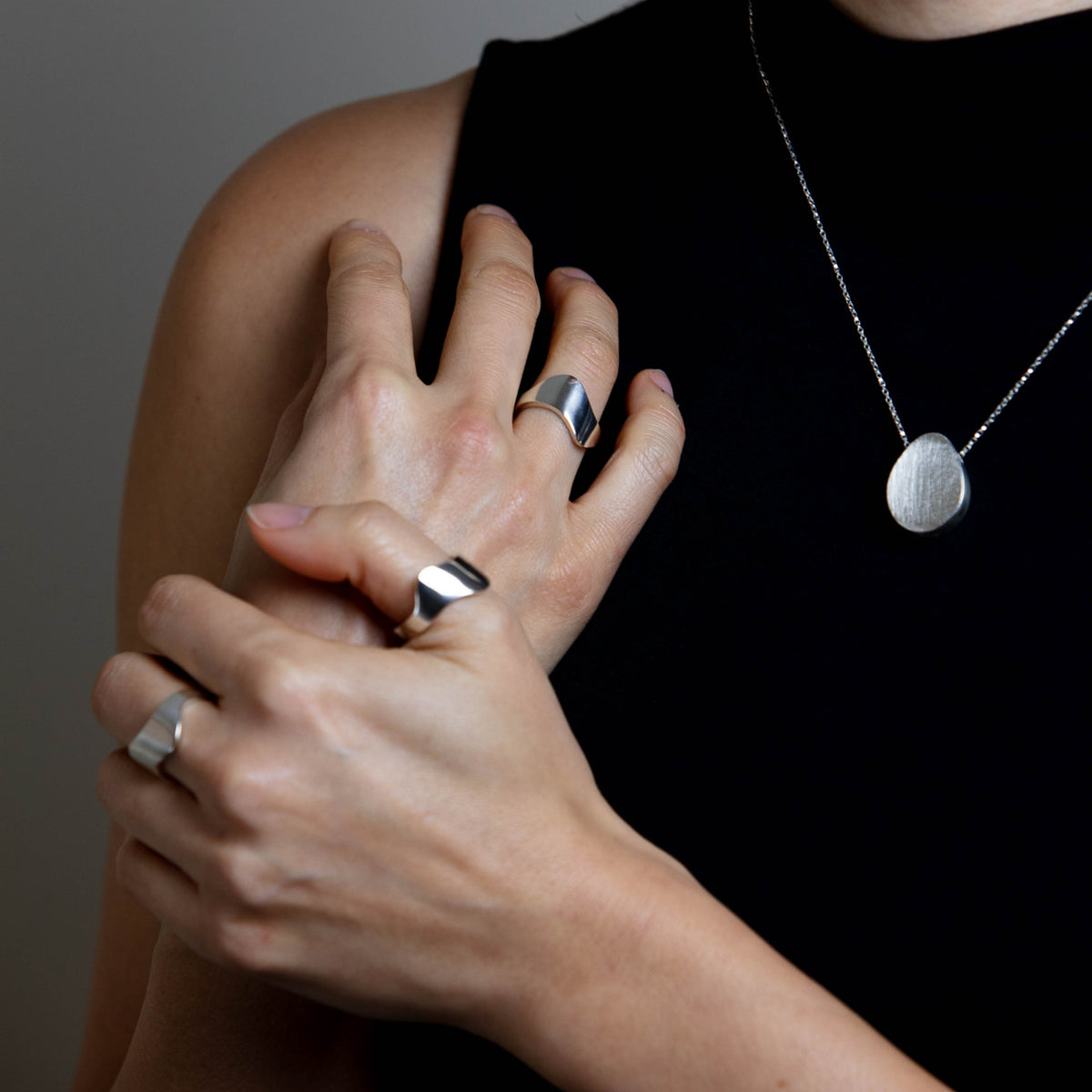two sterling silver rings on wooden block